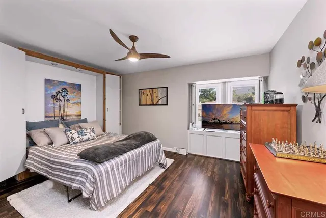 a bedroom with a bed and a dresser with mirror