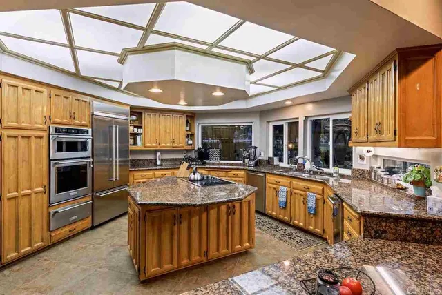 a kitchen with stainless steel appliances granite countertop a stove a sink and a refrigerator