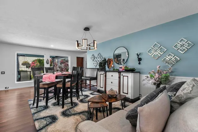 a living room with furniture flat screen tv and large window