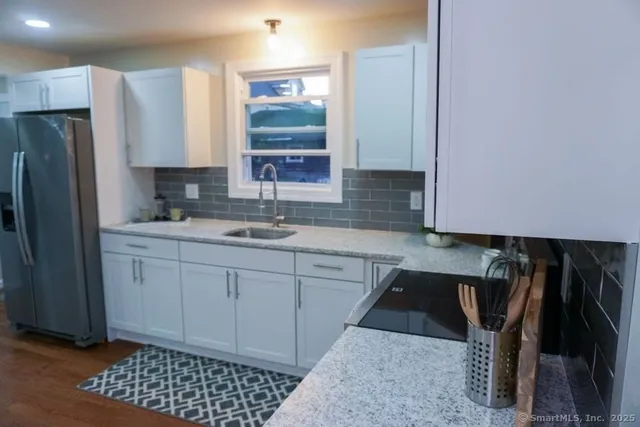 a kitchen with a sink a refrigerator and cabinets