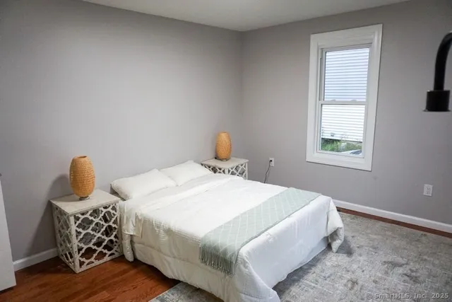 a bedroom with a bed and wooden floor