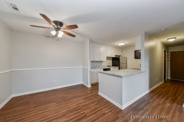 a view of kitchen with faucet wooden floor and stainless steel appliances