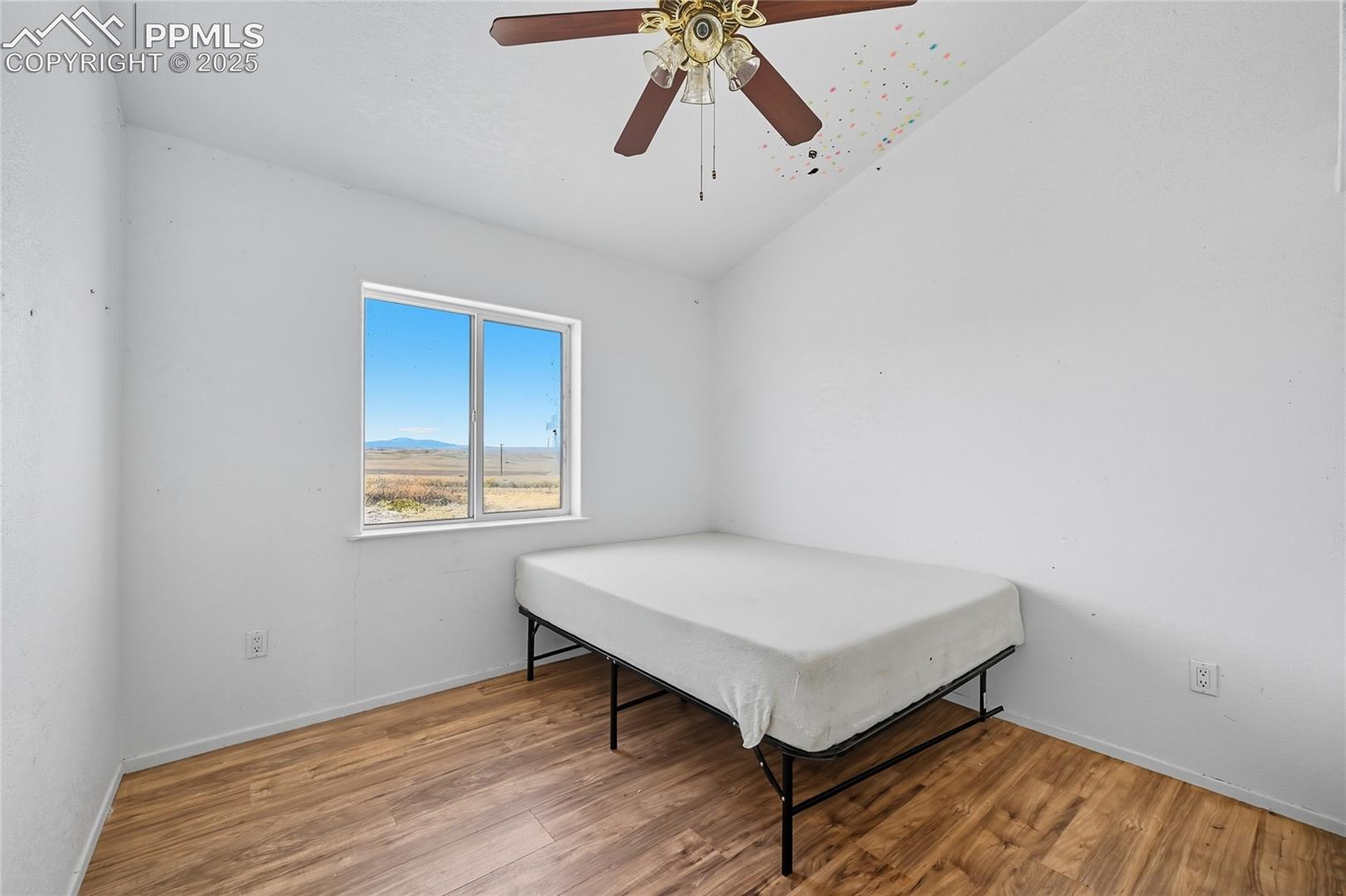 16595 North Yoder Road Calhan, CO 80808 - Photo 22 of 28 Bedroom with vaulted ceiling, light wood-type flooring, ceiling fan, and a mountain view