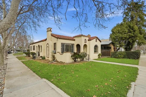 an aerial view of a house with a yard and a large tree