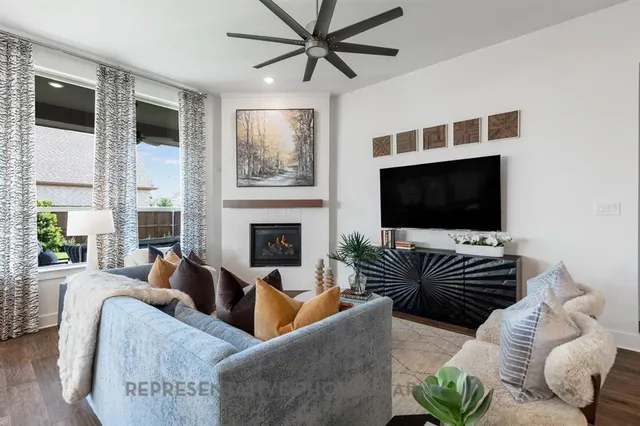a living room with furniture a flat screen tv and a fireplace
