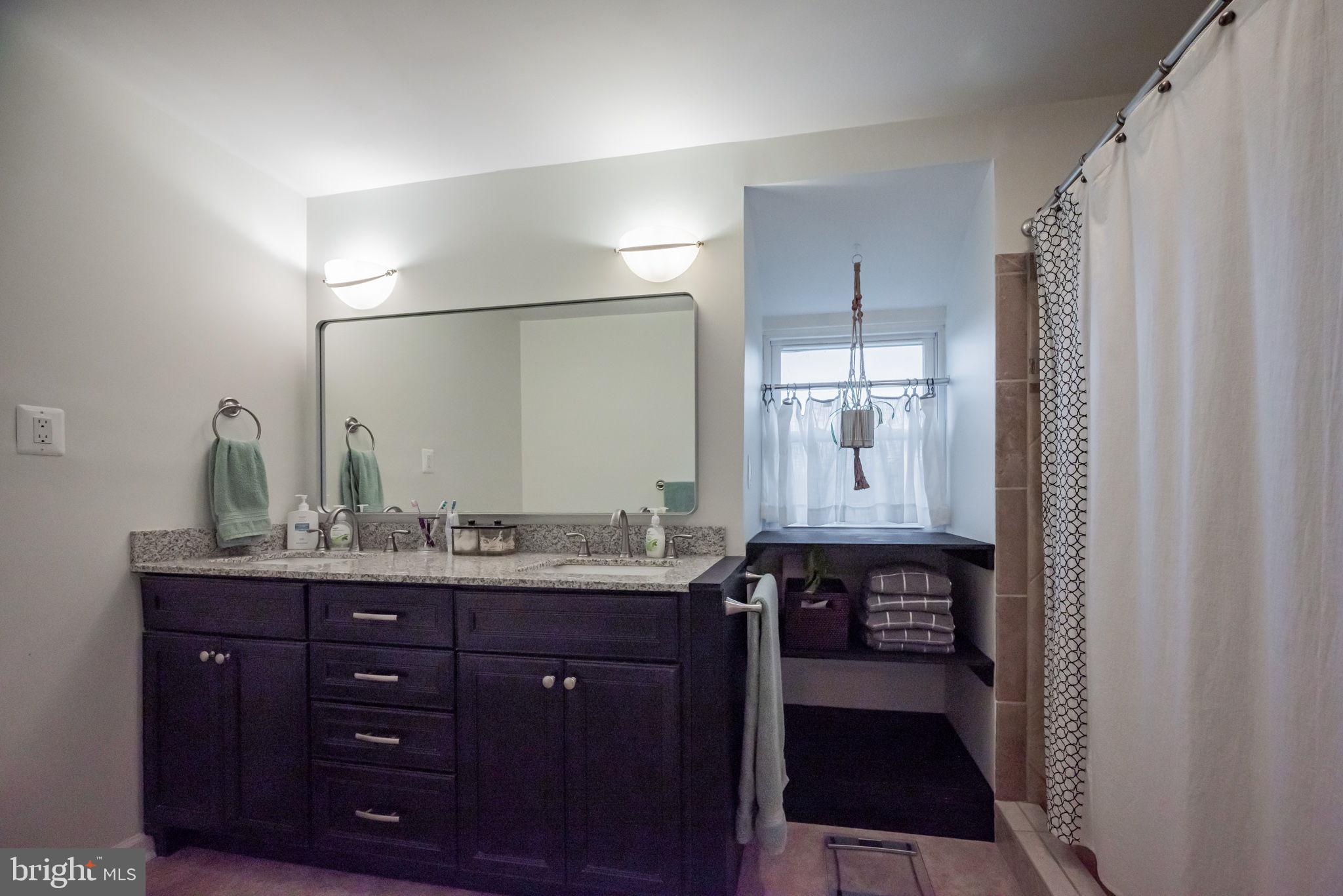 172 Morgantown Road Honey Brook, PA 19344 - Photo 12 of 29 a bathroom with a granite countertop sink a mirror and a shower