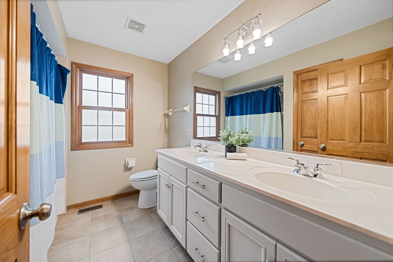 4123 Easy Circle Naperville, IL 60564 - Photo 32 of 45 a spacious bathroom with a double vanity sink a large mirror and a toilet