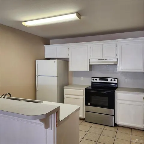 a kitchen with a stove sink and refrigerator