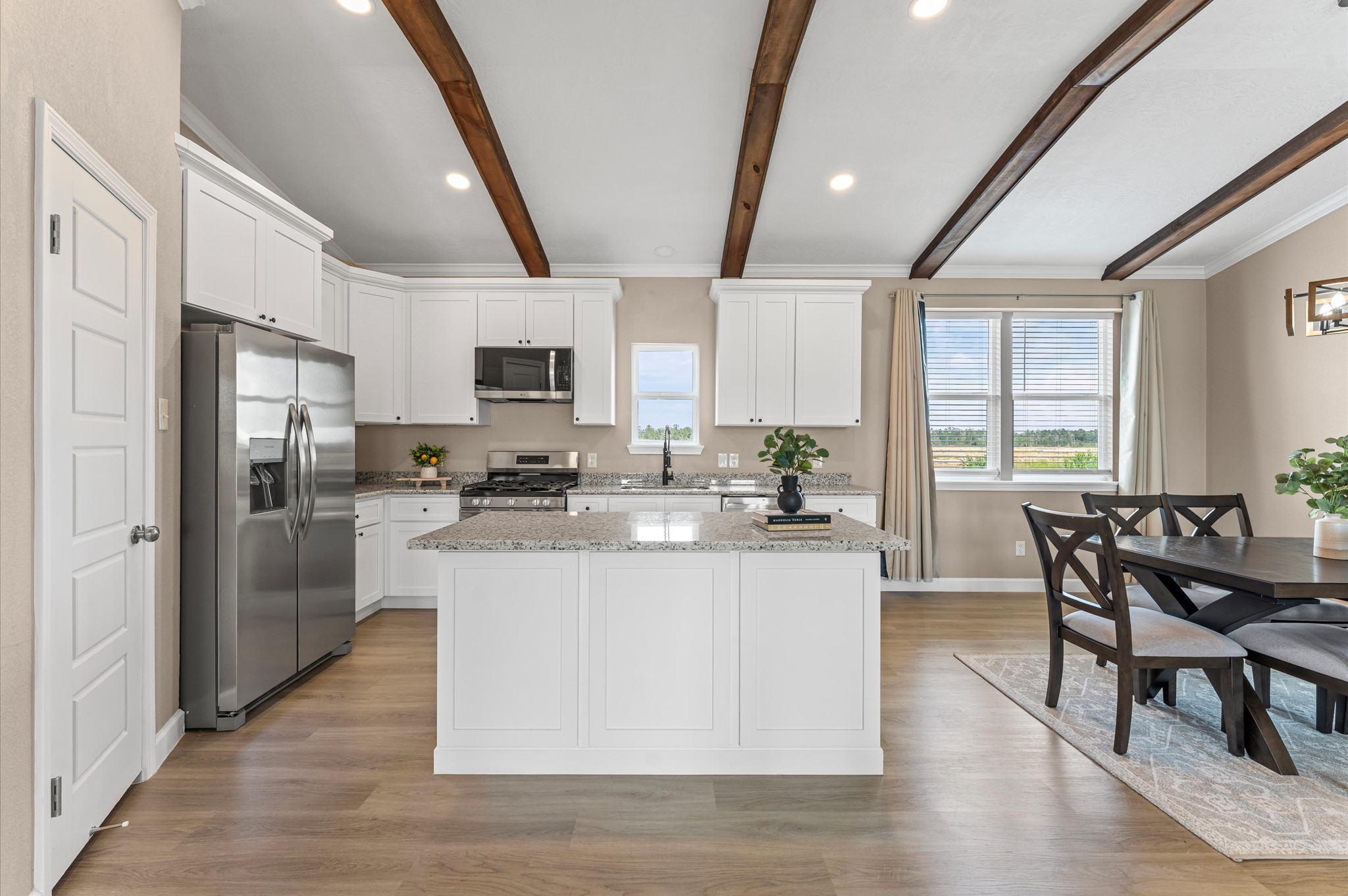 1207 Peter Pne Street Huffman, TX 77336 - Photo 9 of 30 a kitchen with stainless steel appliances granite countertop a stove a refrigerator a kitchen island a dining table and chairs with wooden floor
