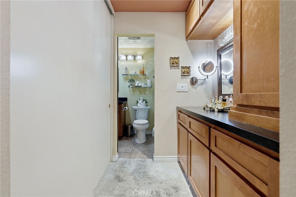 7890 East Spring Street, Unit 2L Long Beach, CA 90815 - Photo 18 of 47 a spacious bathroom with a granite countertop sink a toilet and a mirror