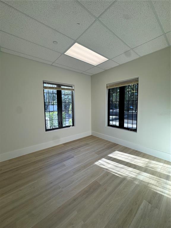 6052 Turkey Lake Road, Unit 118 Orlando, FL 32819 - Photo 6 of 11 an empty room with wooden floor and windows