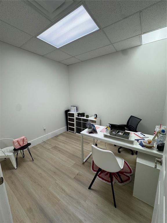 6052 Turkey Lake Road, Unit 118 Orlando, FL 32819 - Photo 9 of 11 a workspace with furniture and wooden floor