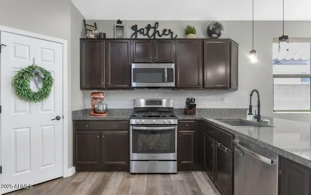 a kitchen with granite countertop a stove microwave and sink