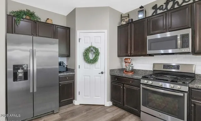 a kitchen with stainless steel appliances and refrigerator