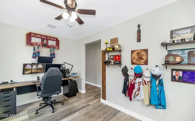 a view of a workspace with furniture and ceiling fan