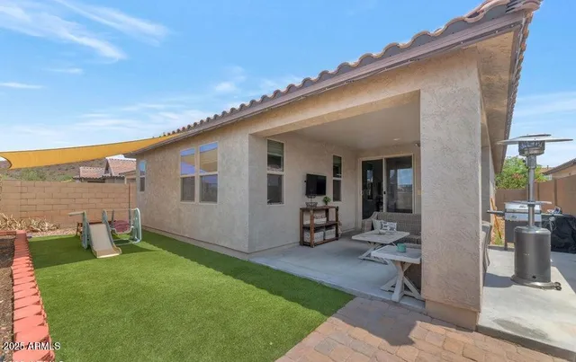 a patio with table and chairs and potted plants