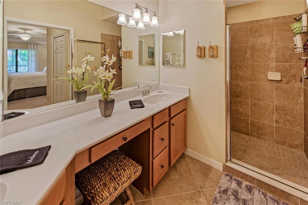 9513 Avellino Way, Unit 2024 Naples, FL 34113 - Photo 17 of 33 a bathroom with a sink a mirror and a shower