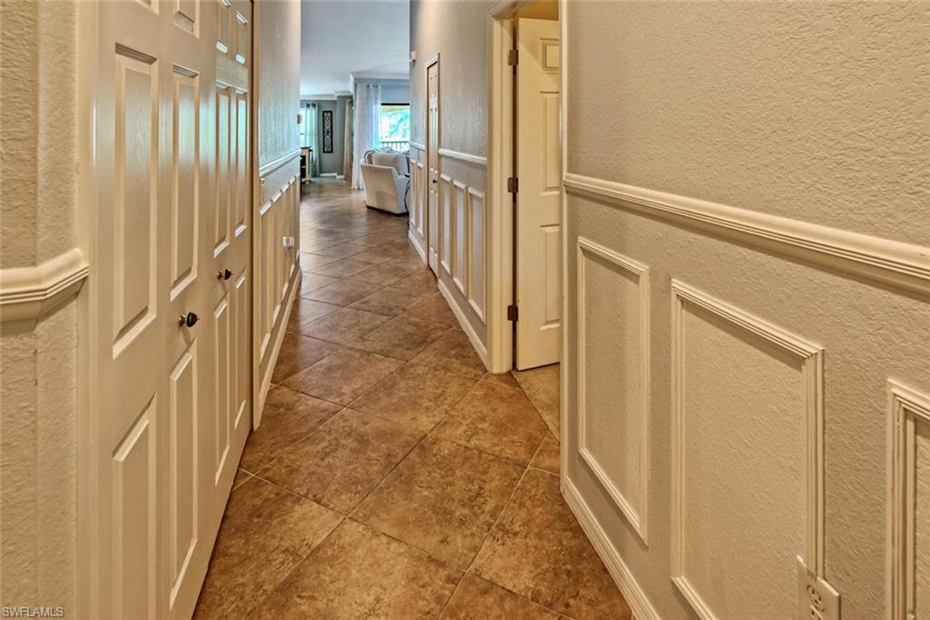 9513 Avellino Way, Unit 2024 Naples, FL 34113 - Photo 7 of 33 a view of a hallway with wooden floor and staircase
