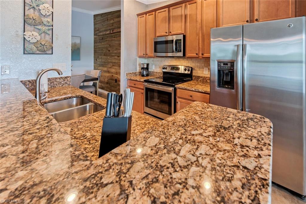9513 Avellino Way, Unit 2024 Naples, FL 34113 - Photo 9 of 33 a kitchen with stainless steel appliances granite countertop a refrigerator a stove top oven and a sink