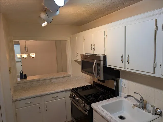 a kitchen with stainless steel appliances a sink stove and cabinets