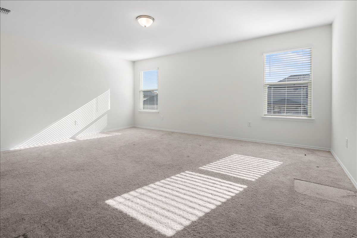 18501 Spotted Eagle Lane Elgin, TX 78621 - Photo 32 of 40 Sun-filled room with plush carpeting and natural light filtering through the windows.