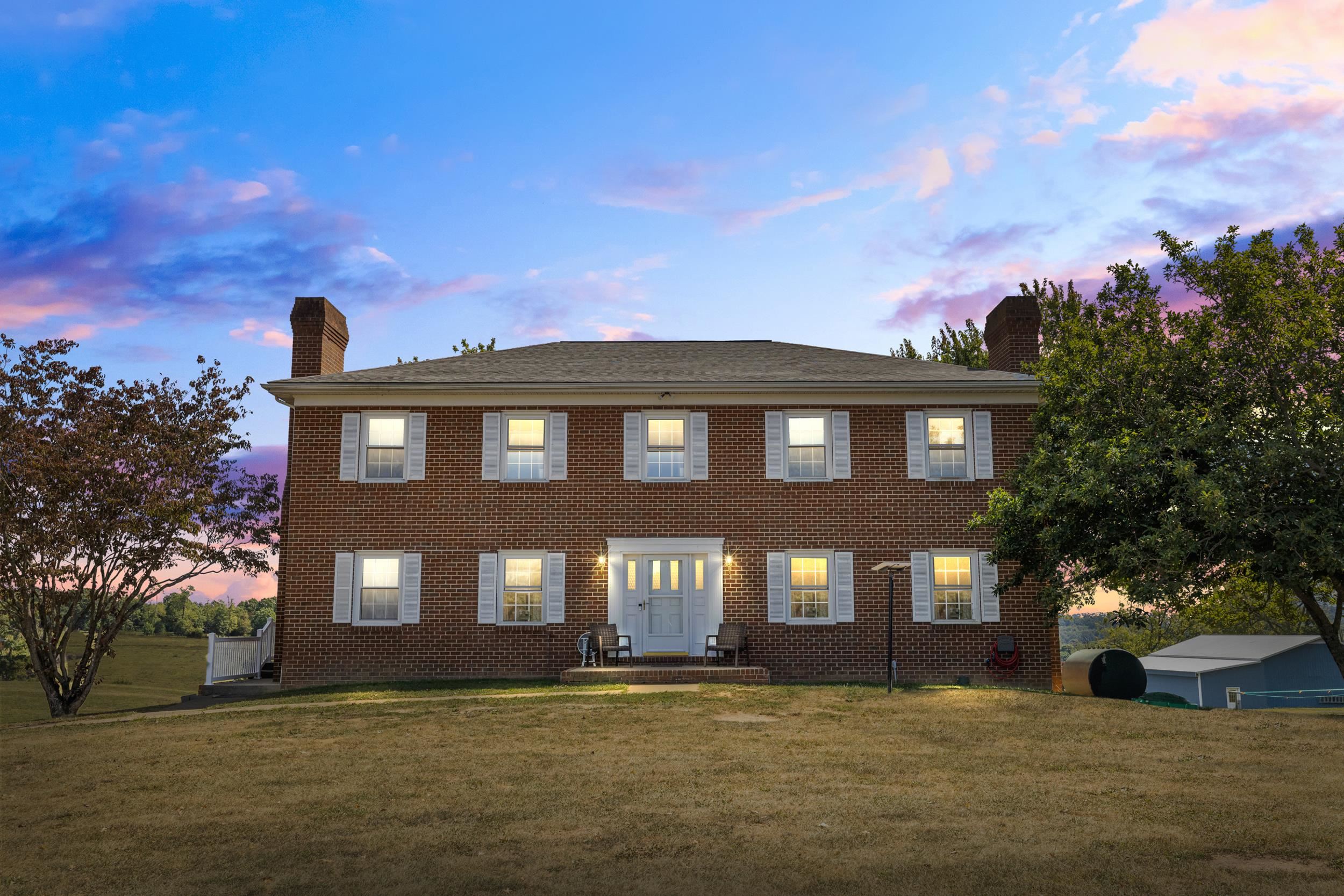a front view of a building with lot of trees