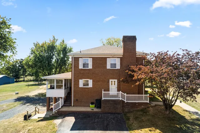 a dining room with wooden floor a fireplace a rug and a large window