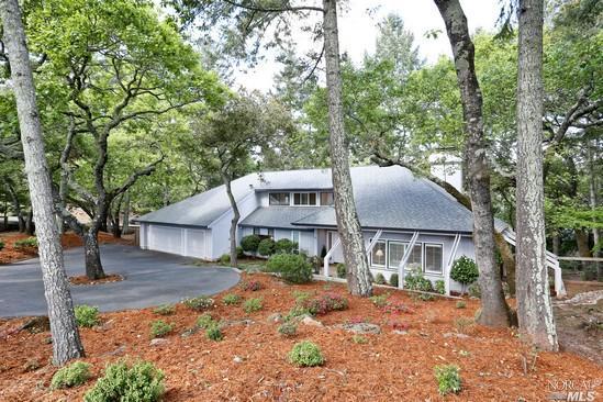 a view of a house with a yard and large trees