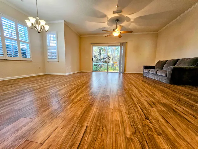 a view of a livingroom with wooden floor and chandelier