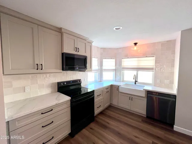 a kitchen with granite countertop a sink stainless steel appliances and cabinets