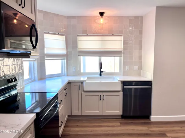 a kitchen with stainless steel appliances granite countertop a sink and a stove