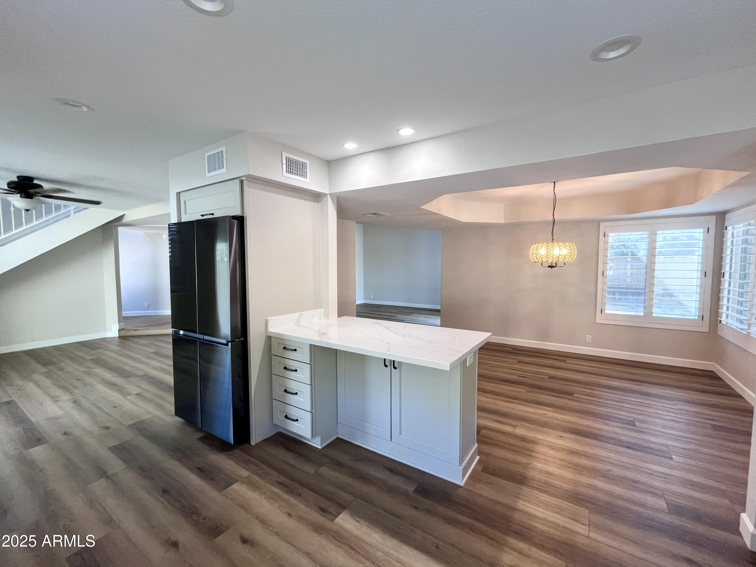 4924 East Hillery Drive Scottsdale, AZ 85254 - Photo 3 of 24 a kitchen with stainless steel appliances a refrigerator and a wooden floor