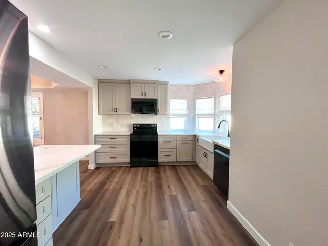 a large kitchen with a wooden floor and stainless steel appliances