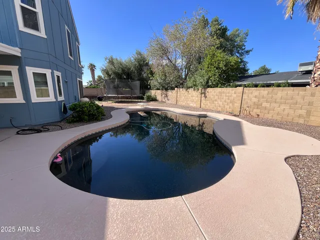 a view of a swimming pool with a house in the background