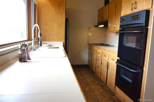 a view of a kitchen with wooden floor and cabinets