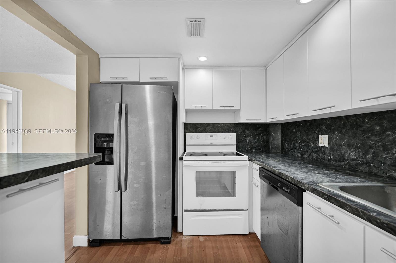 900 Bay Drive, Unit 321 Miami Beach, FL 33141 - Photo 12 of 67 a kitchen with a refrigerator sink and cabinets