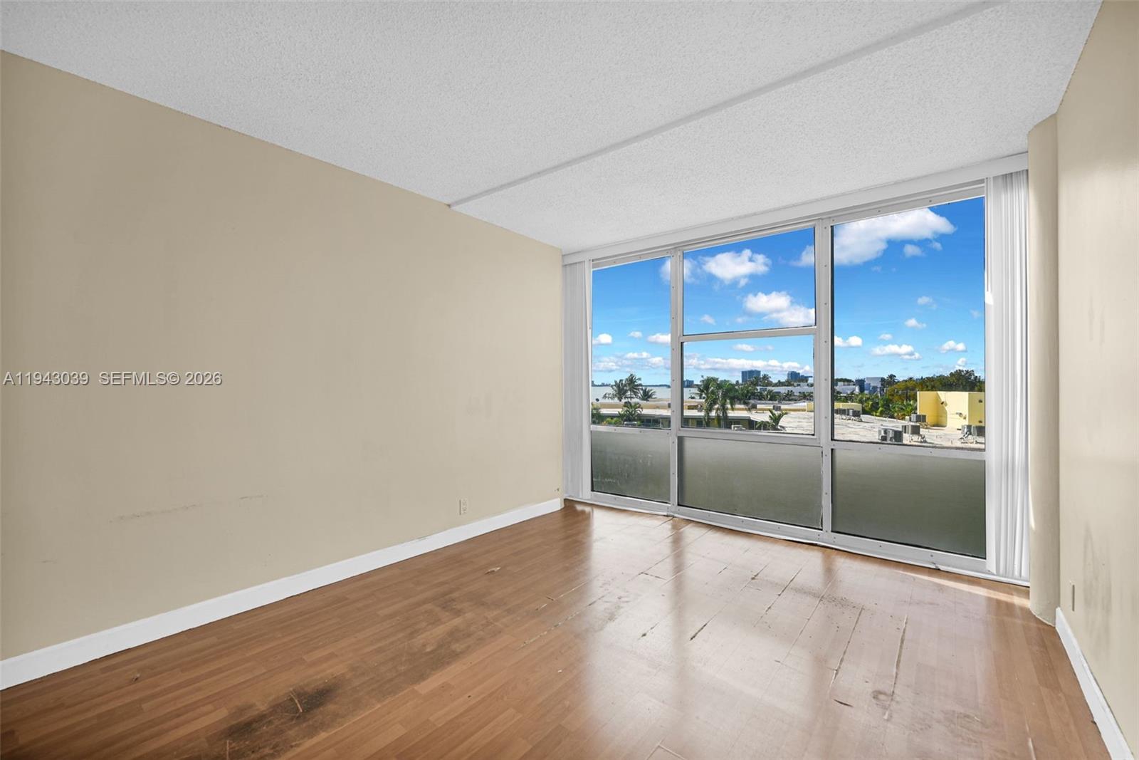 900 Bay Drive, Unit 321 Miami Beach, FL 33141 - Photo 19 of 67 an empty room with wooden floor and large window