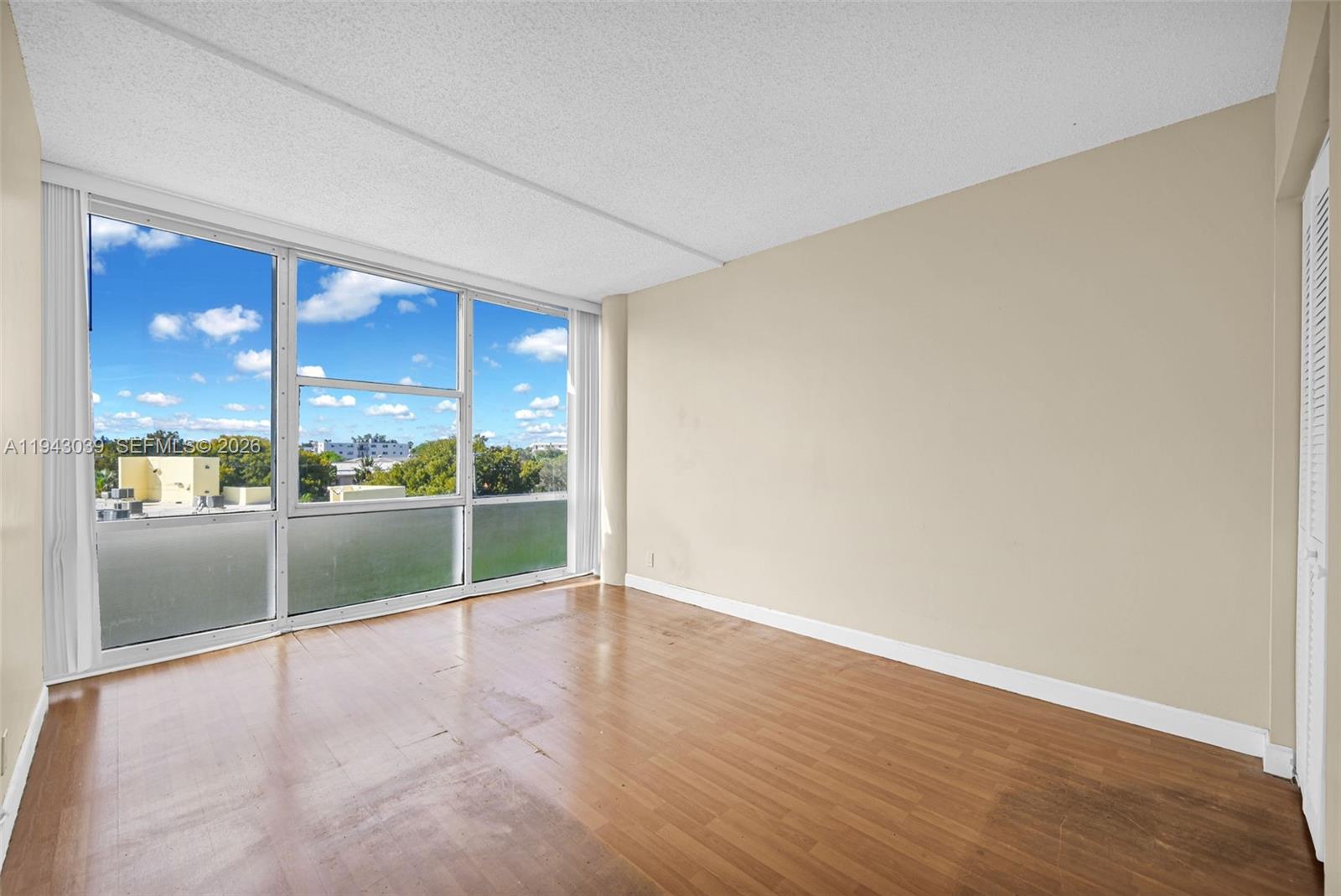 900 Bay Drive, Unit 321 Miami Beach, FL 33141 - Photo 20 of 67 an empty room with wooden floor and windows