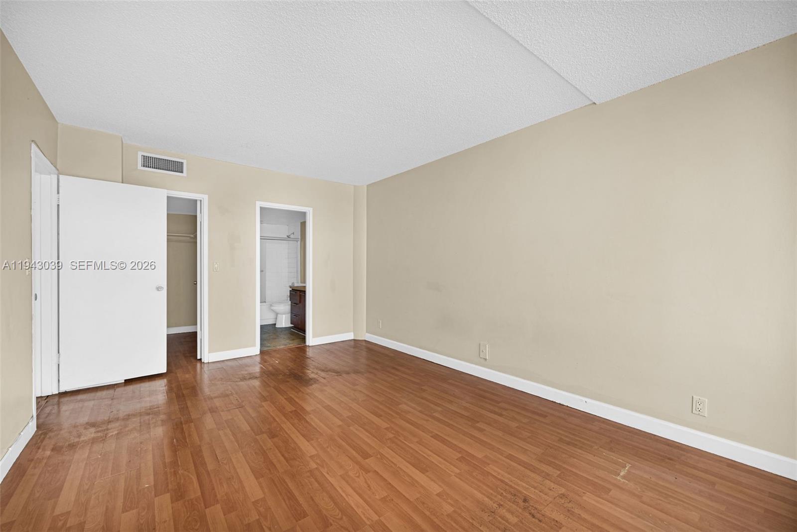 900 Bay Drive, Unit 321 Miami Beach, FL 33141 - Photo 24 of 67 a view of an empty room with wooden floor and a window