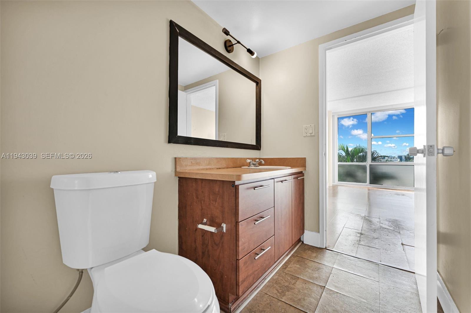 900 Bay Drive, Unit 321 Miami Beach, FL 33141 - Photo 30 of 67 a bathroom with a toilet a sink a vanity and mirror