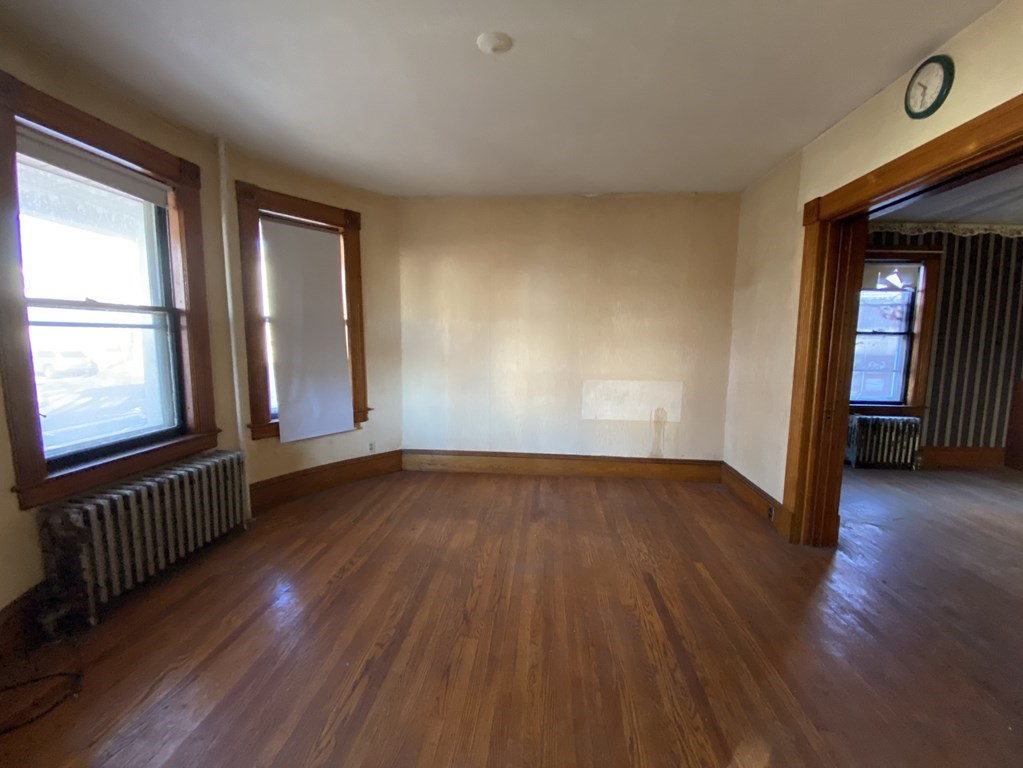 231 Orange Street Springfield, MA 01108 - Photo 3 of 22 an empty room with wooden floor and windows