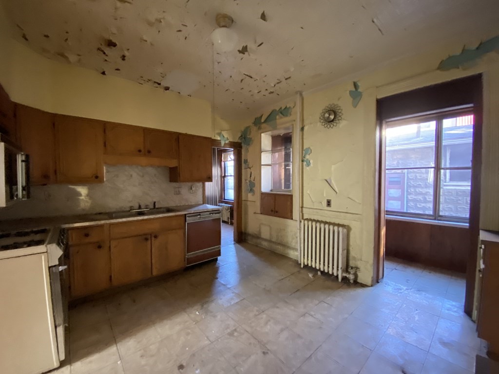 231 Orange Street Springfield, MA 01108 - Photo 8 of 22 a large kitchen with a large window and stainless steel appliances