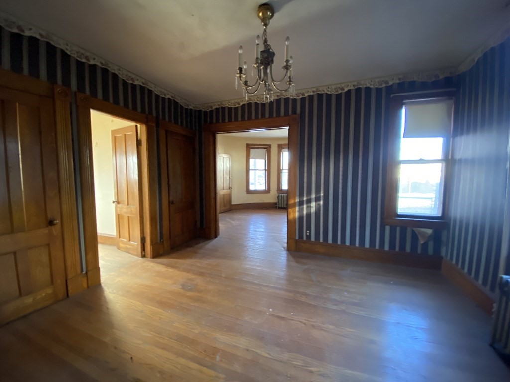231 Orange Street Springfield, MA 01108 - Photo 9 of 22 an empty room with wooden floor and windows