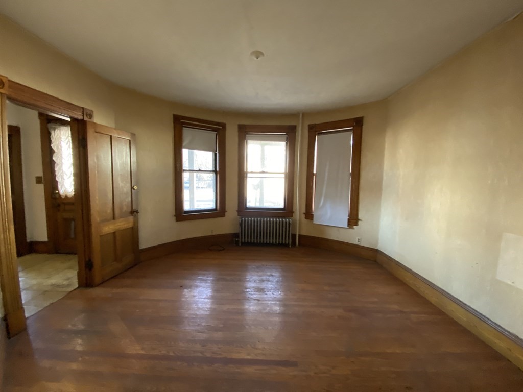 231 Orange Street Springfield, MA 01108 - Photo 10 of 22 an empty room with wooden floor and windows