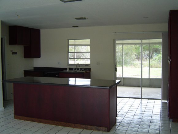 759 Northeast Apollo Palm Bay, FL 32905 - Photo 3 of 12 a kitchen with kitchen island a counter top space wooden floor and a large window