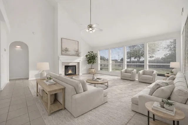a living room with furniture large window and a fireplace