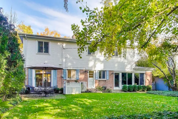 a front view of a house with a garden and trees