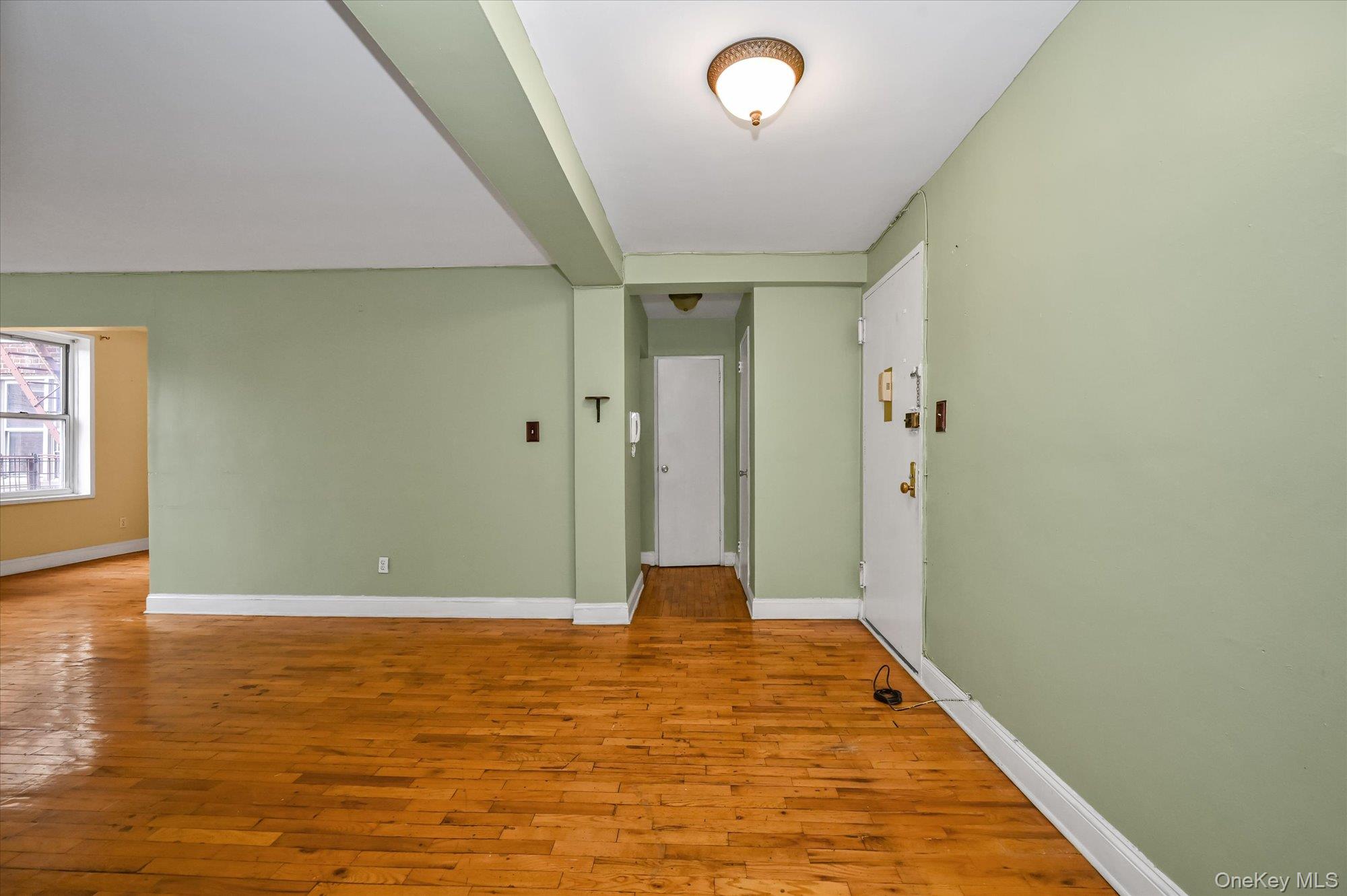 59-30 108th Street, Unit 4P Queens, NY 11368 - Photo 4 of 18 wooden floor in an empty room with a gallery