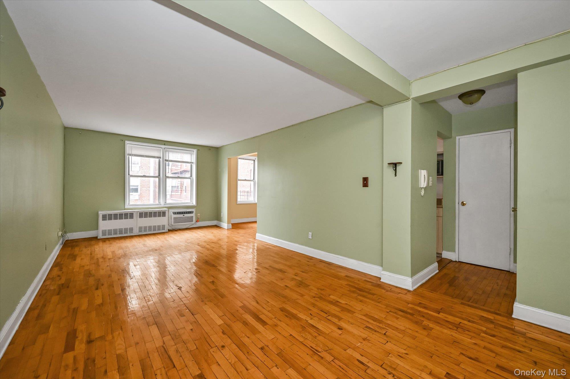 59-30 108th Street, Unit 4P Queens, NY 11368 - Photo 6 of 18 a view of an empty room with window and wooden floor