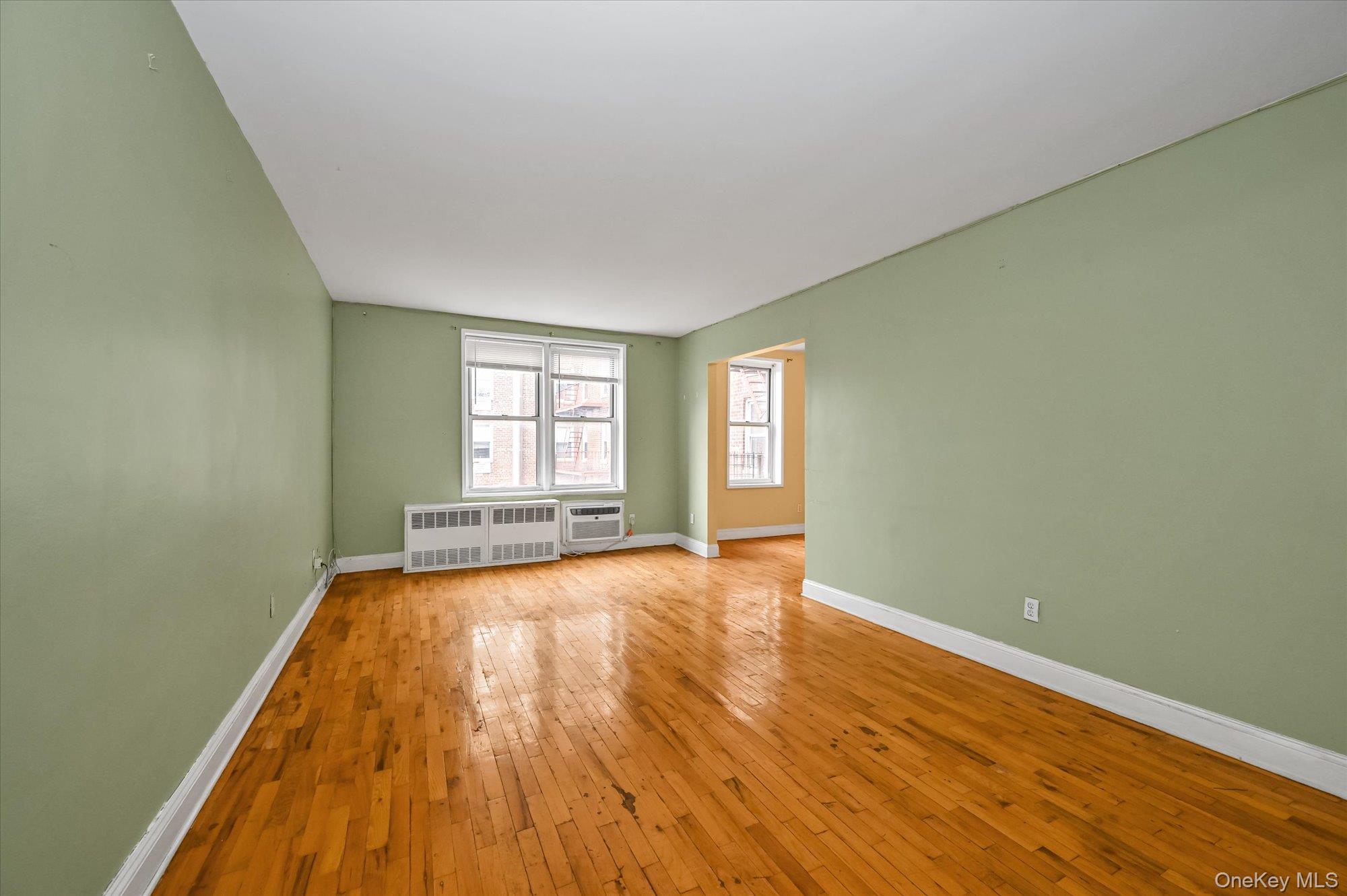 59-30 108th Street, Unit 4P Queens, NY 11368 - Photo 7 of 18 a view of an empty room with wooden floor and a window